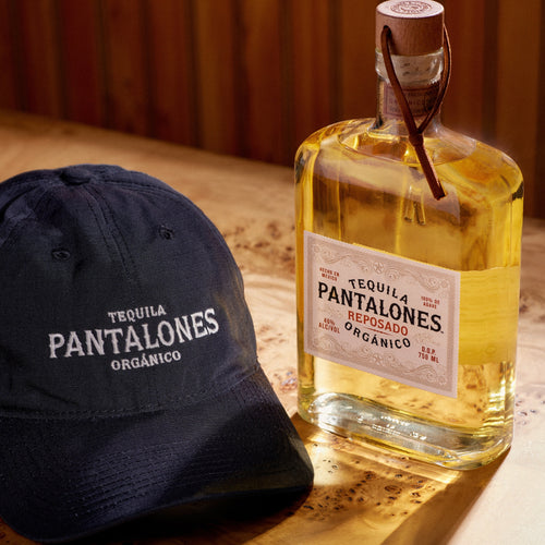 Pantalones Reposado Tequila aged in oak barrels with classic black dad hat