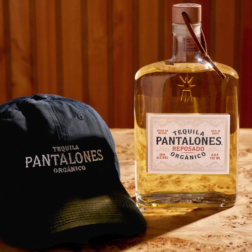 Pantalones Reposado Tequila aged in oak barrels with classic black dad hat